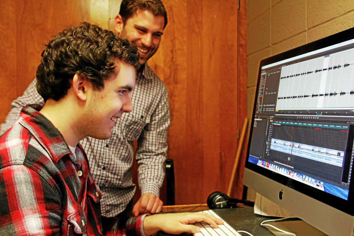 Torrington High School sophomore Evan Dunlap (seated) laughs as he gets some editing advice from Benjamin Willis of the Civic Life Project on Wednesday, May 21, 2014, in Torrington. Register Citizen Esteban L. Hernandez