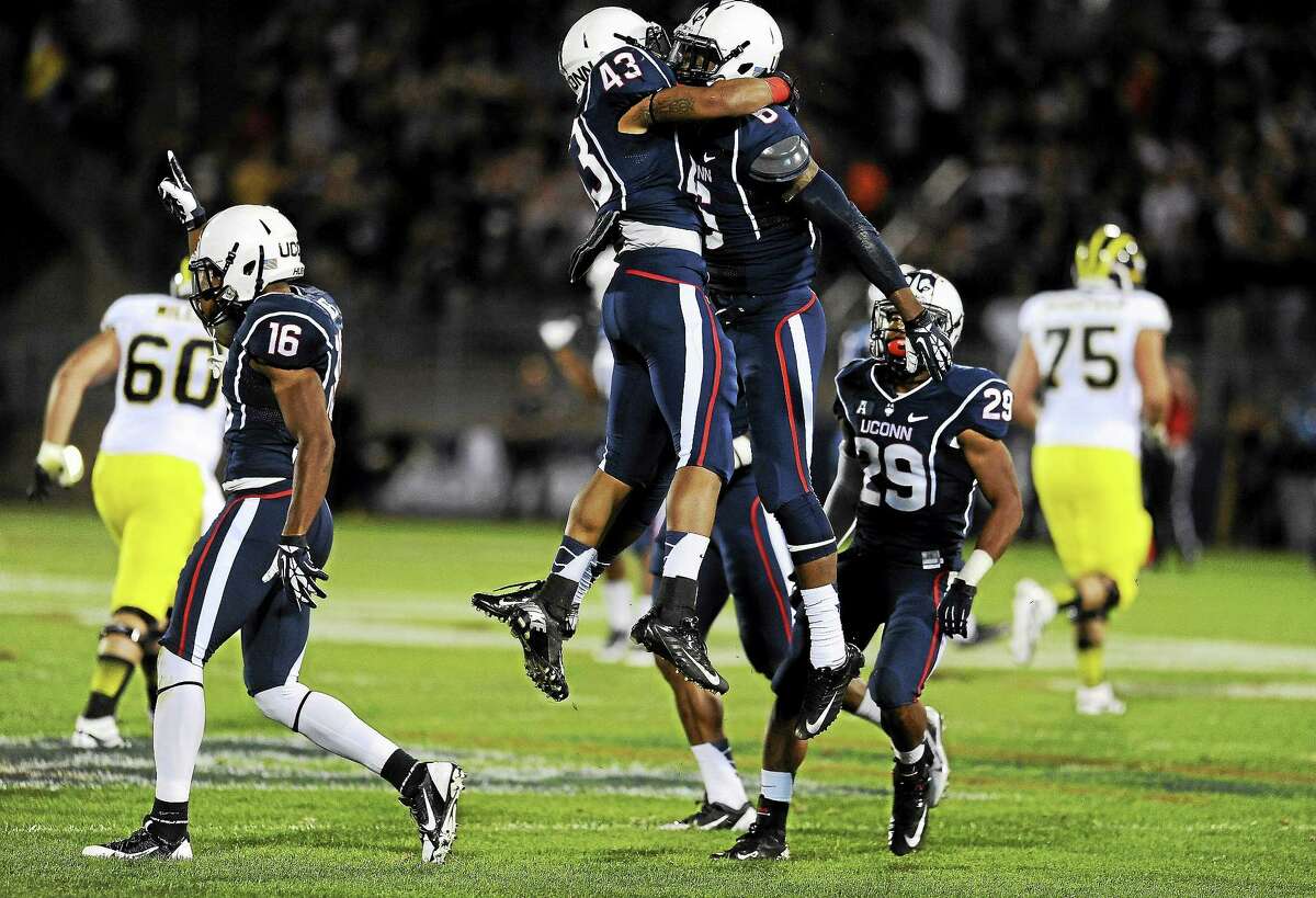 UConn cornerback Jhavon Williams celebrates with running back Lyle McCombs (43) after intercepting a pass against Michigan last September at Rentschler Field in East Hartford.