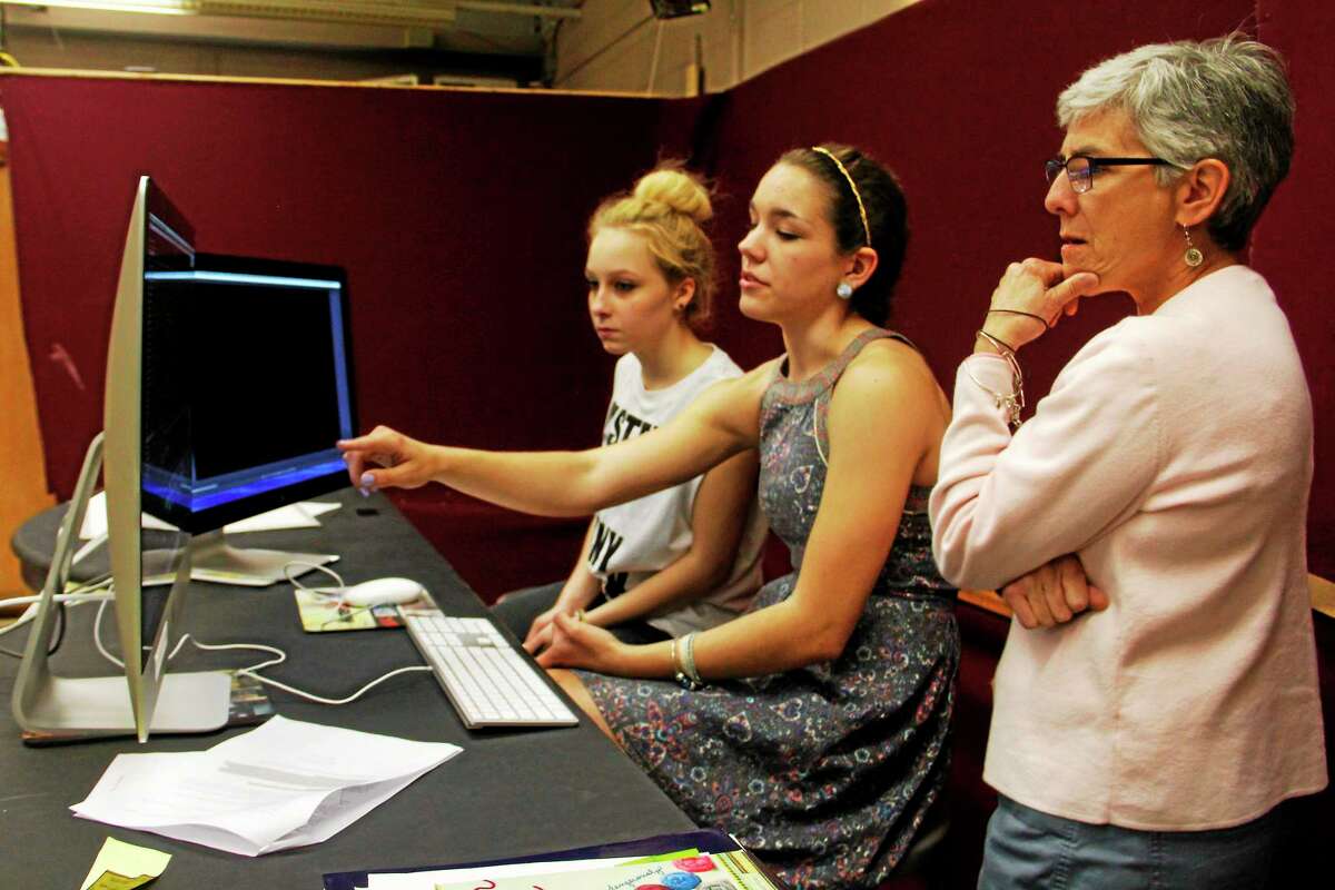 From left: Torrington High School sophomores Marielle Franco and Elizabeth Garcia discuss editing a documentary with adviser and schools library media specialist Robin Magistrali on Wednesday, May 21, 2014, in Torrington. The students are in a technology class called ìCitizenship and Actionî and are part of an 18-student class producing two documentaries. Register Citizen Esteban L. Hernandez