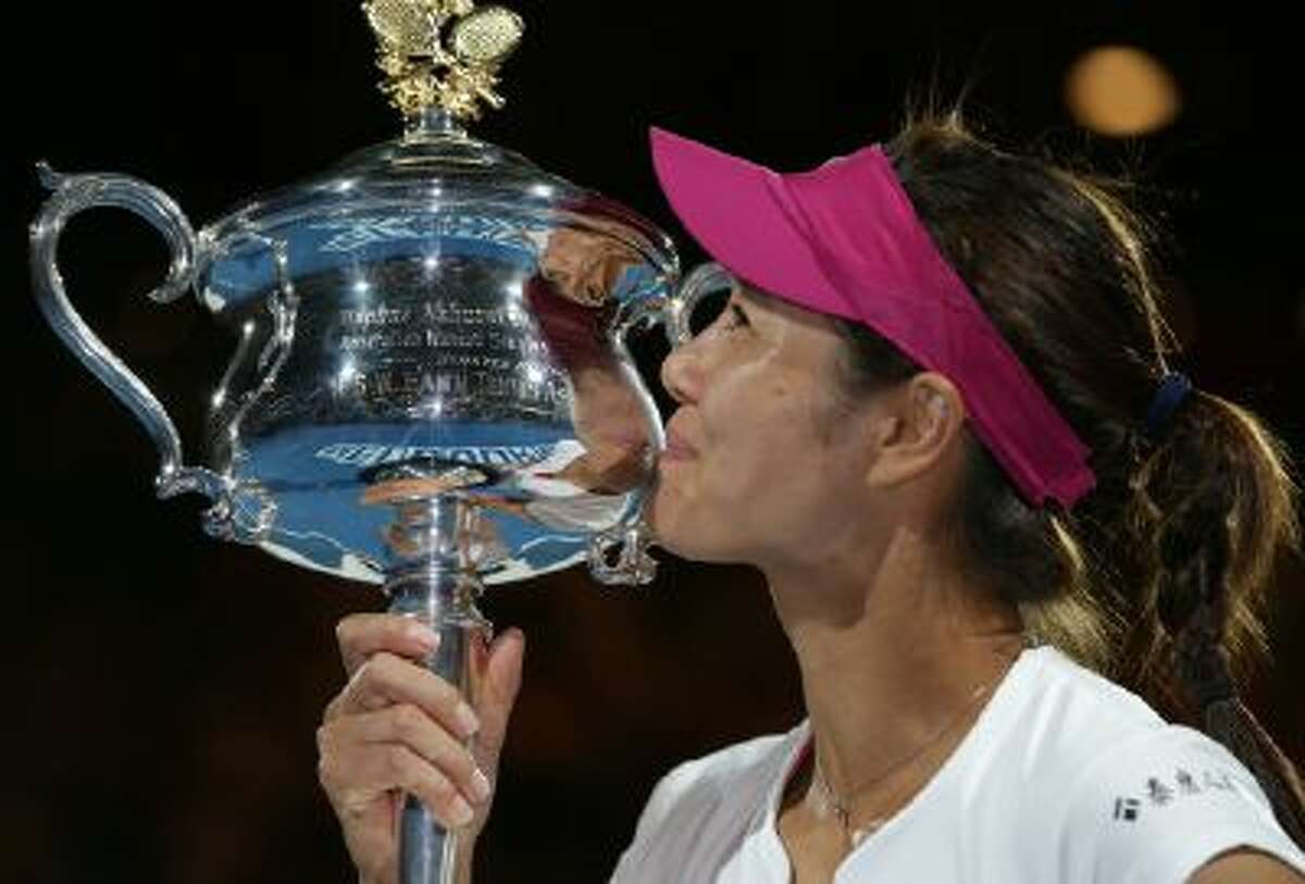 Li Na of China kisses the championship trophy after defeating Dominika Cibulkova of Slovakia in their women's singles final at the Australian Open Saturday.