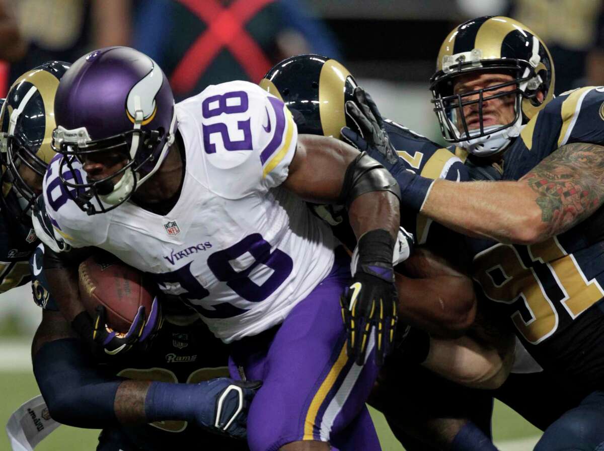 Minnesota Vikings running back Adrian Peterson runs for a 5-yard gain as Rams defensive end Chris Long defends during a Sept. 7 game in St. Louis.
