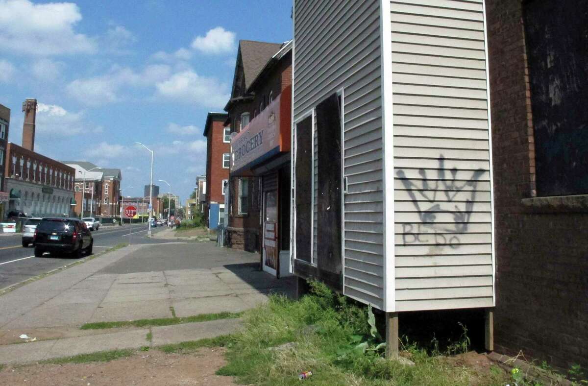 In this Sept. 5, 2014 photo, Latin Kings gang graffiti decorates a building in Hartford. While gangs still mark their territory with graffiti, police said many members have shied away from wearing their colors in an effort to avoid being detected by authorities.