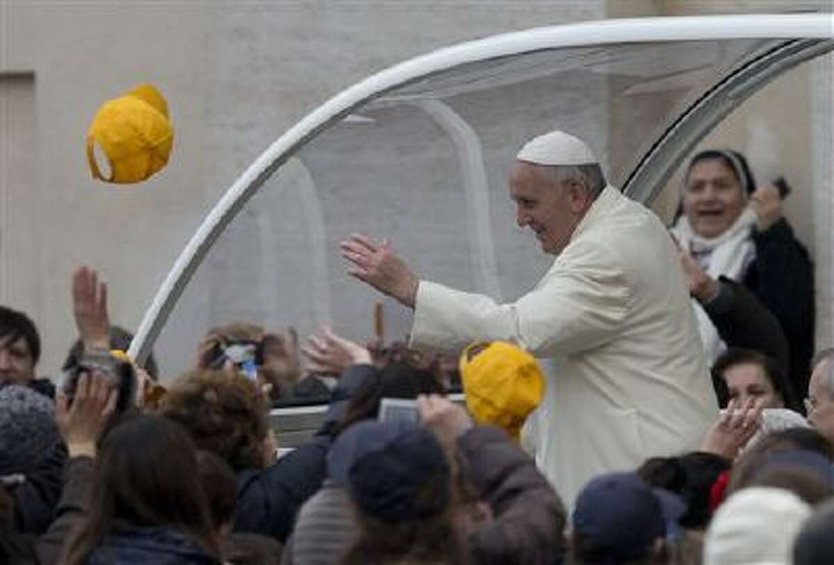 A cap is thrown toward Pope Francis as he arrives Wednesday in his pope-moblie for his weekly general audience in St. Peter's Square at the Vatican.