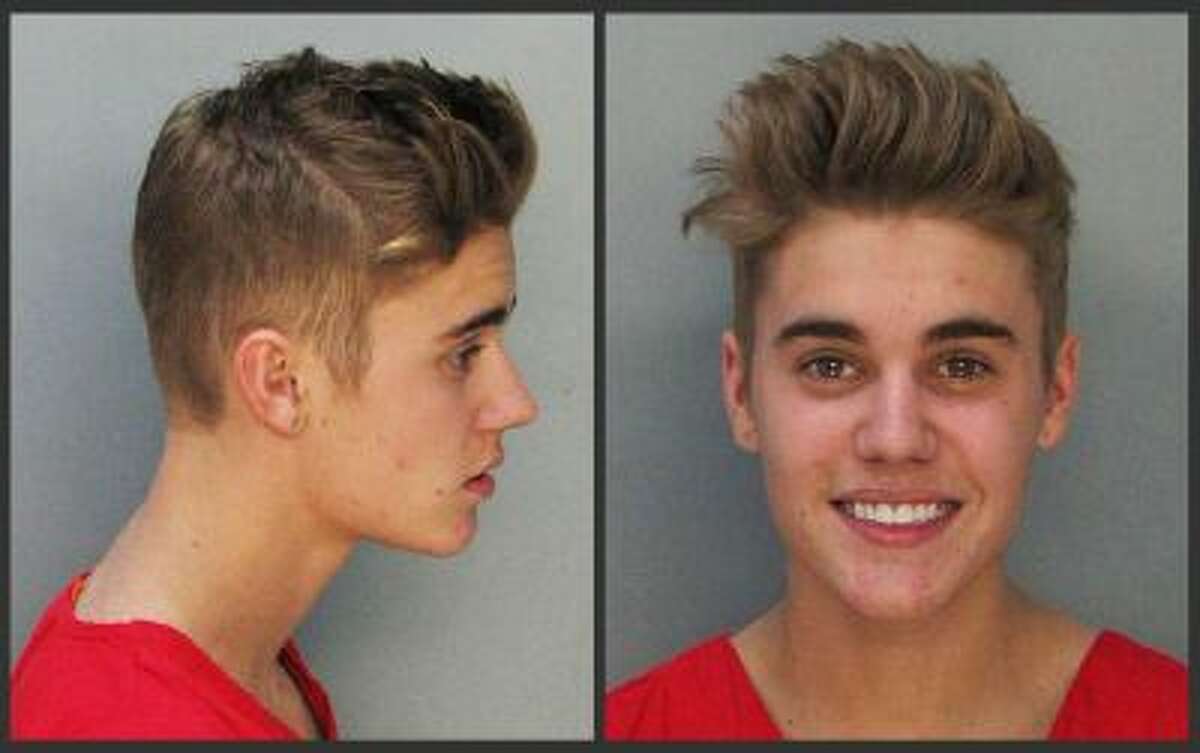 These police booking mugs made available by the Miami Dade County Corrections Department show pop star Justin Bieber, Thursday, Jan. 23, 2014. Bieber and singer Khalil were arrested early Thursday for allegedly drag-racing on a Miami Beach Street.