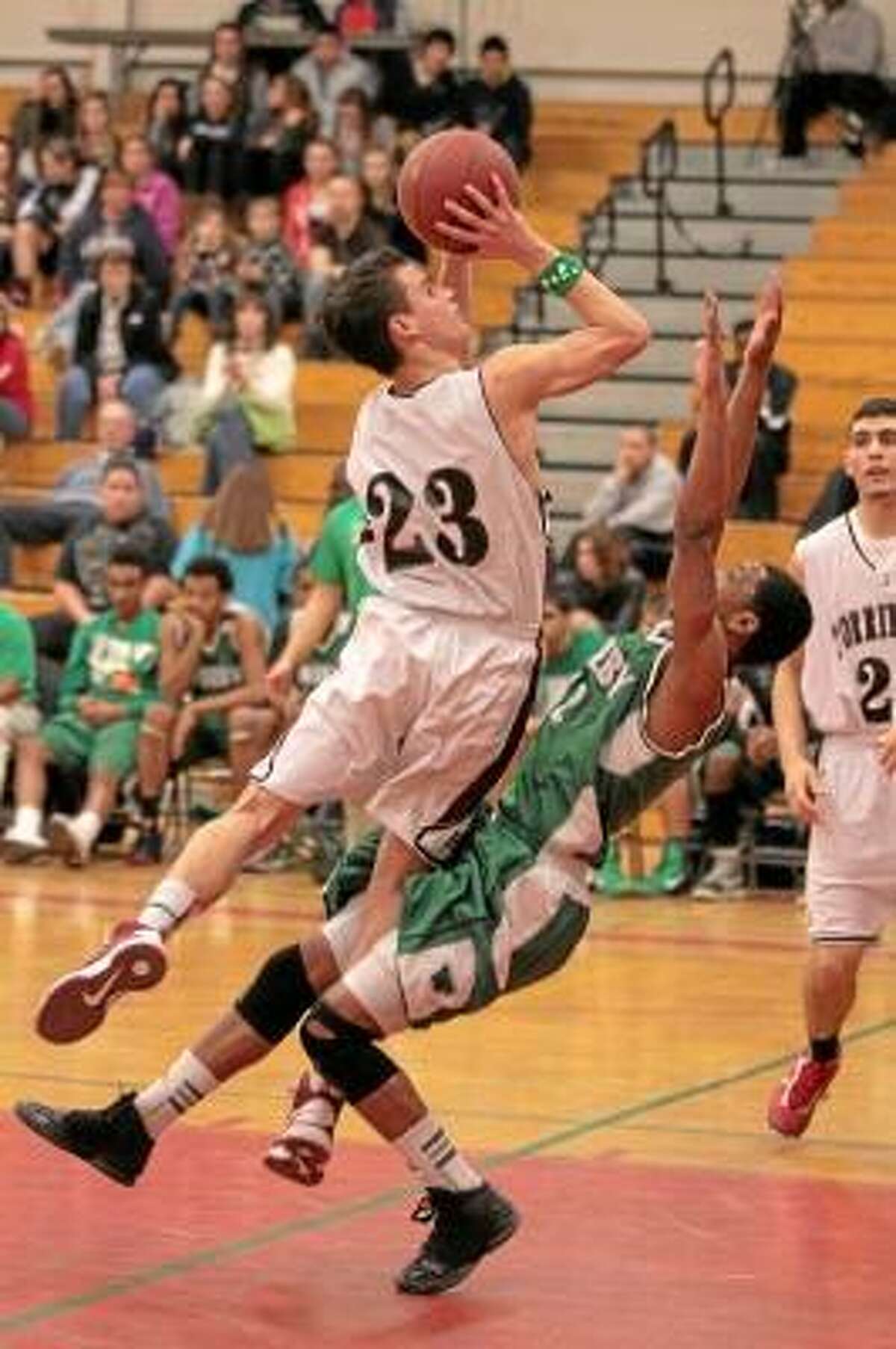 Torrington's Austin Kelson (23) collides with a Wilby defender as he goes for a layup. Marianne Killackey/Special to Register Citizen.