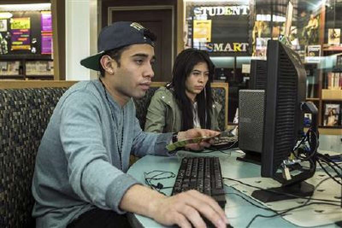 19-year-olds Alexander Alegria and Michelle Rivera use computers to access the Internet at the Teen'Scape area at the Los Angeles Public Library in Los Angeles.