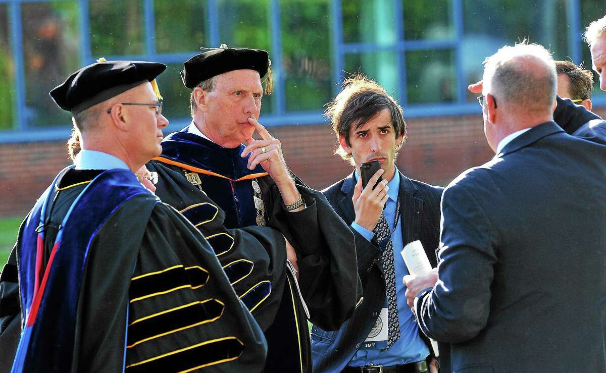 Quinnipiac University President John Lahey, second from left, talks with police and security officials moments before deciding to move the graduation ceremony from the main campus to the TD Bank Arena because of ‘multiple security threats.’ 5/18/14 pcasolino@newhavenregister.com