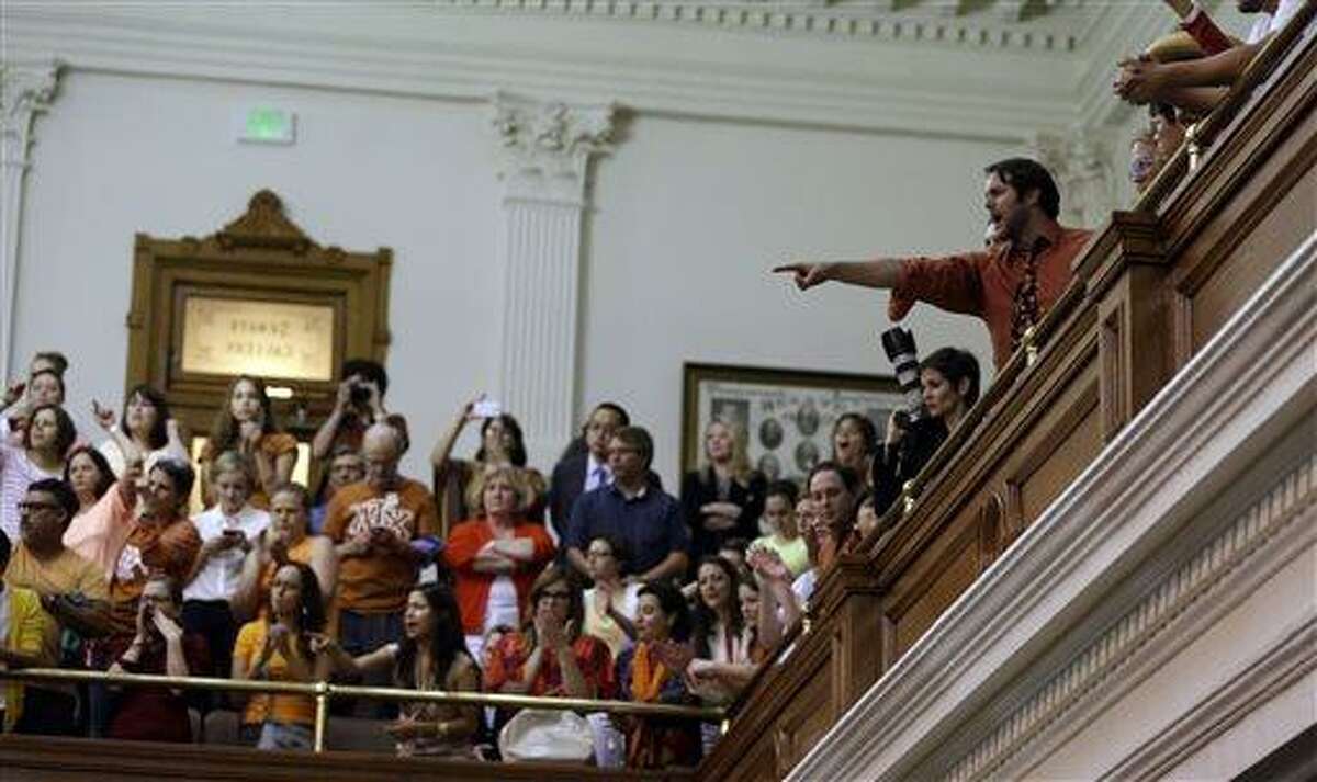 Members of the gallery cheer and chant as the Texas Senate tries to bring an abortion bill to a vote as time expires, Wednesday, June 26, 2013, in Austin, Texas. Amid the deafening roar of abortion rights supporters, Texas Republicans huddled around the Senate podium to pass new abortion restrictions, but whether the vote was cast before or after midnight is in dispute. If signed into law, the measures would close almost every abortion clinic in Texas. (AP Photo/Eric Gay)