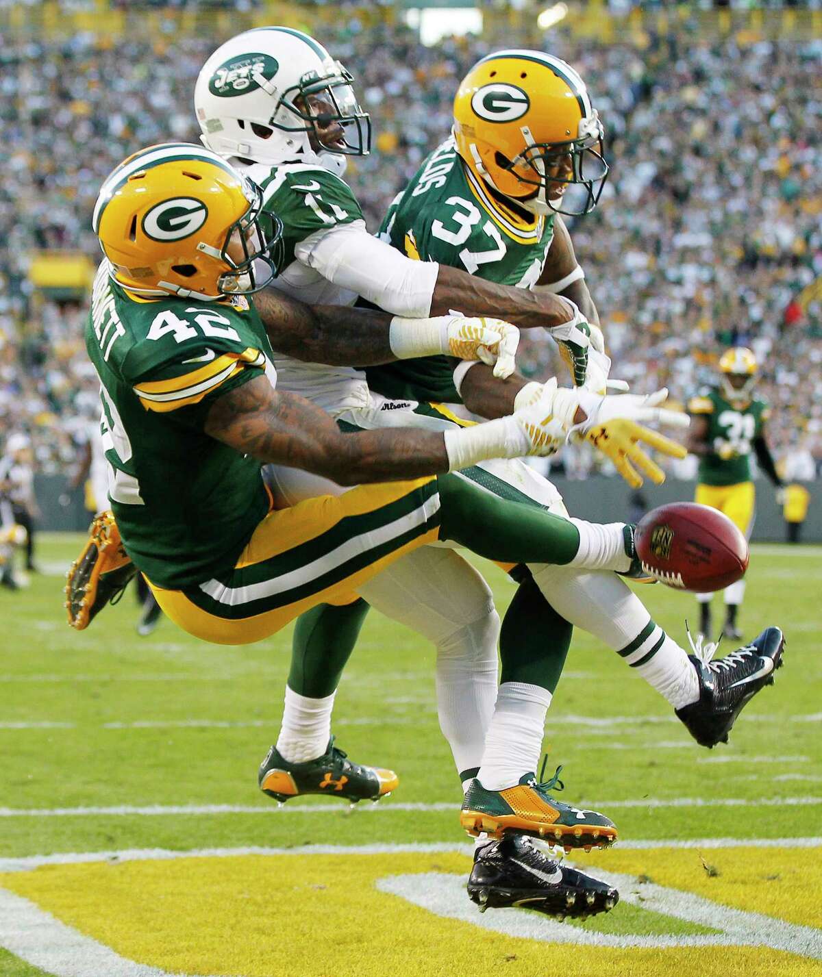 Green Bay Packers’ Sam Shields (37) and Morgan Burnett break up a pass intended for New York Jets’ Jeremy Kerley during the second half Sunday.