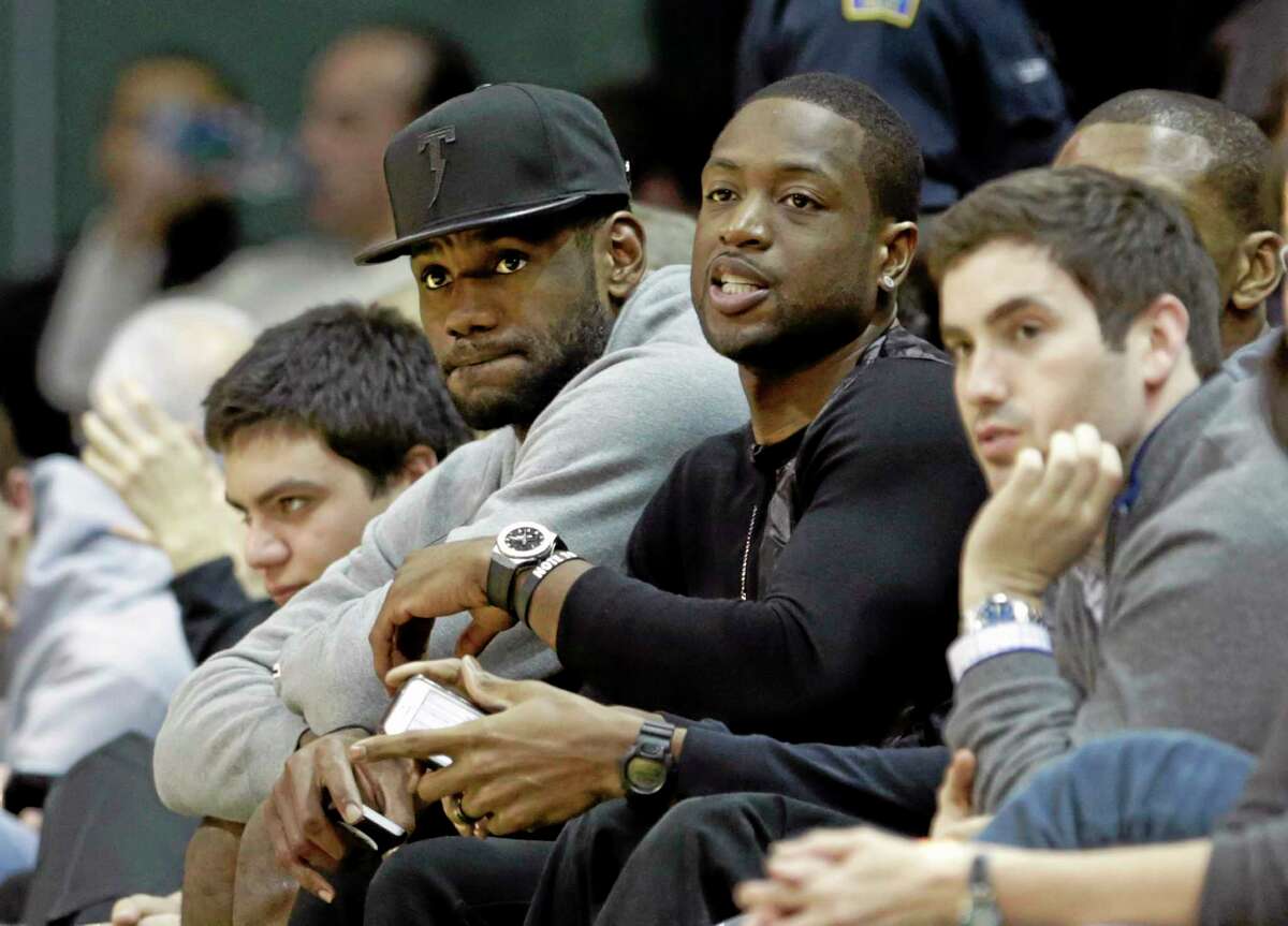 The Miami Heat’s LeBron James, left, and Dwyane Wade watch the Duke/Miami game Wednesday night in Coral Gables, Fla. Duke coach Mike Krzyzewski and James will reunite once again to lead USA Basketball.