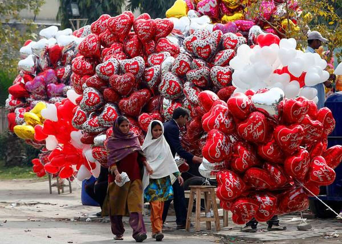 Women walk past heart-shaped balloons on Valentine's Day in Lahore, February 14, 2013. REUTERS/Mohsin Raza
