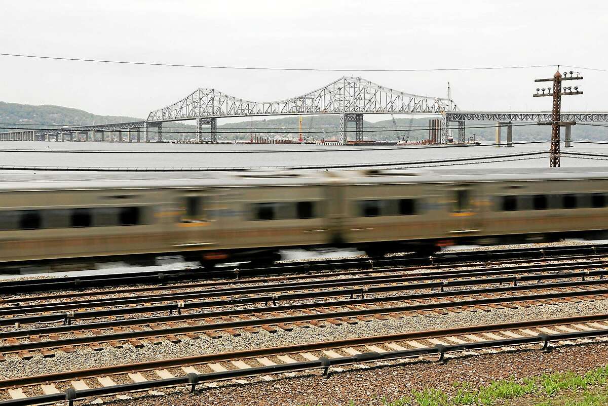 A Metro-North train streaks along the Hudson River just south of the Tappan Zee Bridge in Tarrytown, N.Y.