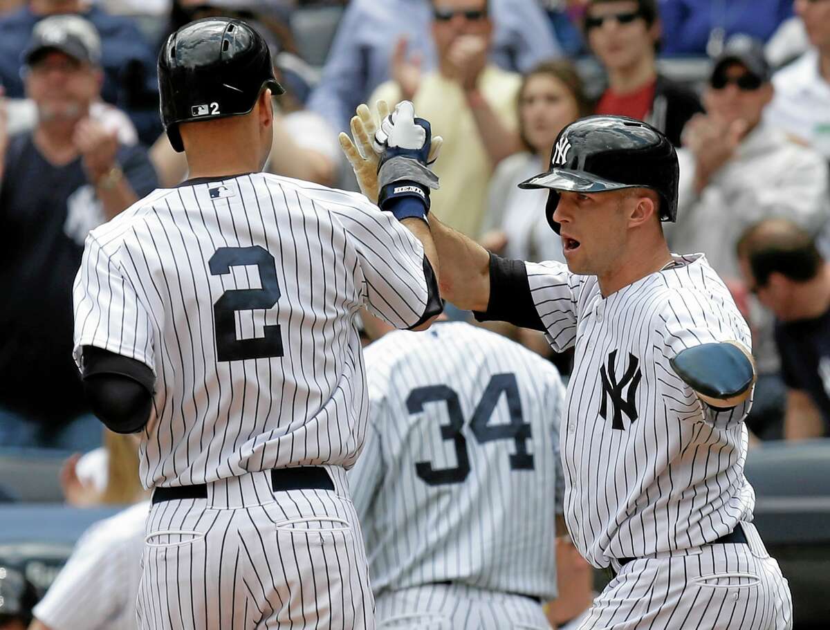 The Yankees’ Brett Gardner, right, greets Derek Jeter (2) at home plate after they scored in the first inning of the first game of a doubleheader against the Pirates on Sunday.