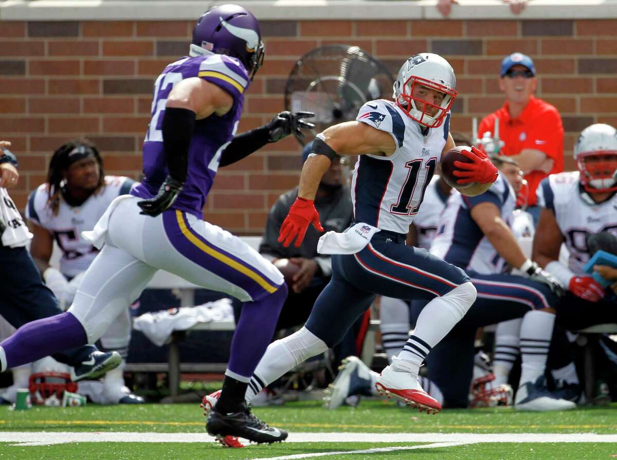 Patriots wide receiver Julian Edelman, right, runs with the ball past Vikings free safety Harrison Smith after catching a pass during the second quarter Sunday.