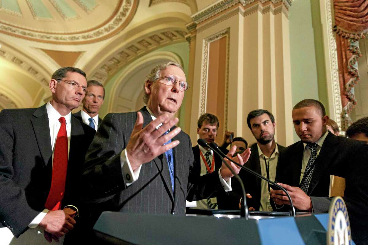 Senate Minority Leader Mitch McConnell, R-Ky., joined by Sen. John Barrasso, R-Wyo., left, and Sen. John Thune, R-S.D., rear left, speaks to reporters after a Republican caucus meeting, at the Capitol in Washington, Tuesday, May 6, 2014. (AP Photo/J. Scott Applewhite)