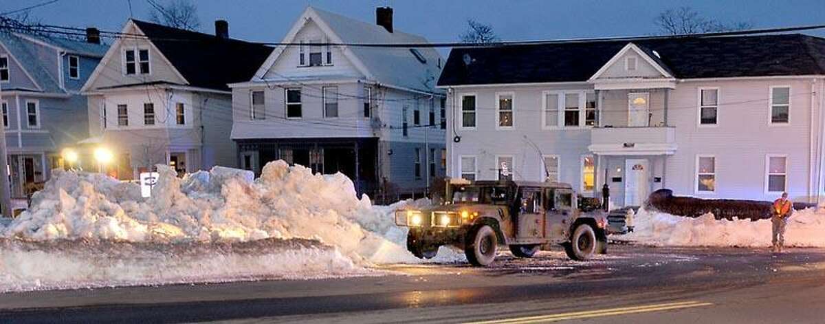 Pennsylvania Air National Guard from the 201st Red Horse Unit and the 228 BSB based in Fort Indiantown Gap in Pennsylvania set up a road block so their team can work with heavy equipment and shovels Wednesday February 13, 2013 clearing out Blizzard 2013 snow on Plymouth Street in New Haven, Connecticut New Haven, Connecticut. Photo by Peter Hvizdak / New Haven Register