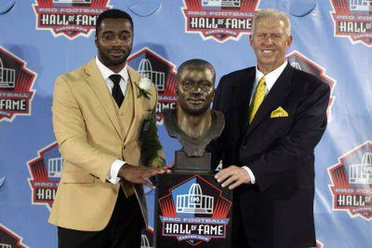Curtis Martin and former head coach Bill Parcells pose for a photograph with Martin's bust at the 2012 Hall of Fame Enshrinee Ceremony at Fawcett Stadium in Canton, Ohio on August 4, 2012.