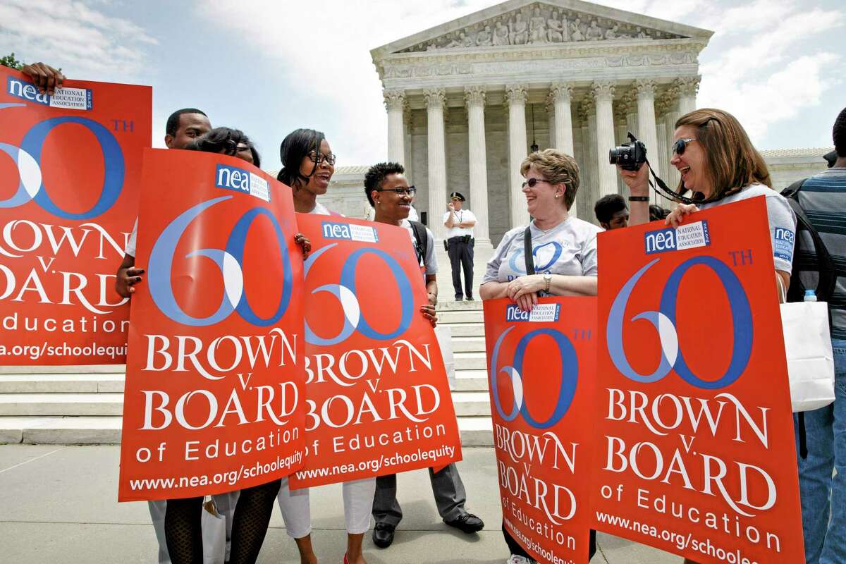 This photo taken May 13, 2014 ,shows National Education Association staff members from Washington joining students, parents and educators at a rally at the Supreme Court in Washington on the 60th anniversary Brown v. Board of Education decision that struck down ìseparate but equalî laws that kept schools segregated. Saturday marks the 60th anniversary of the landmark Brown v. Board of Education decision. Many inequities in education still exist for black students and for Hispanics, a population that has grown exponentially since the 1954 ruling.