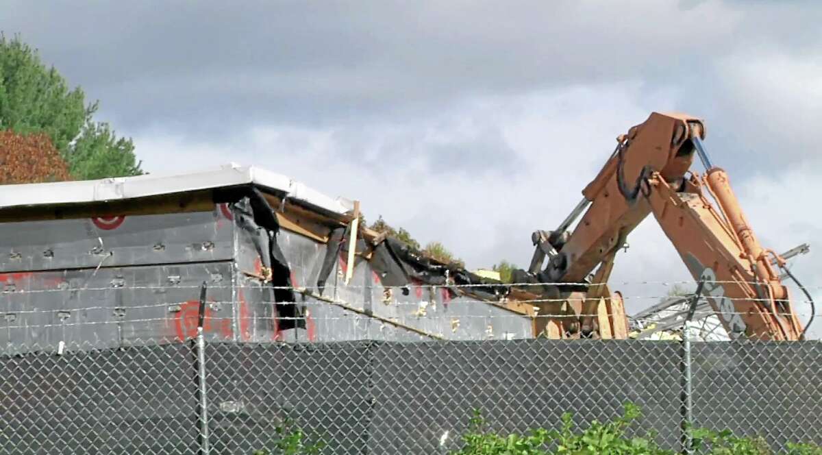 In this image taken from video, a backhoe rips into the roof of the Sandy Hook Elementary School in Newtown as demolition begins on the building.