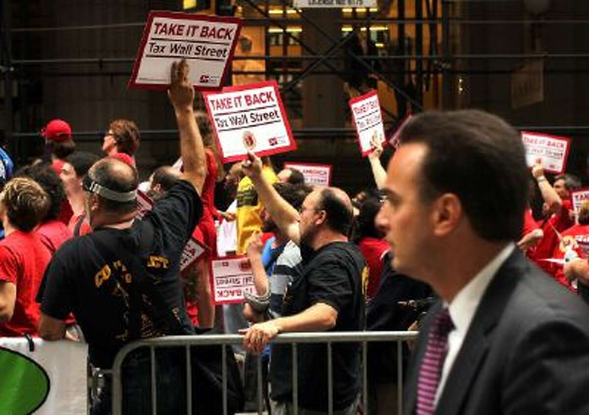 A man walks by a union protest on Wall Street against financial intuitions and inequality in New York City in 2011.