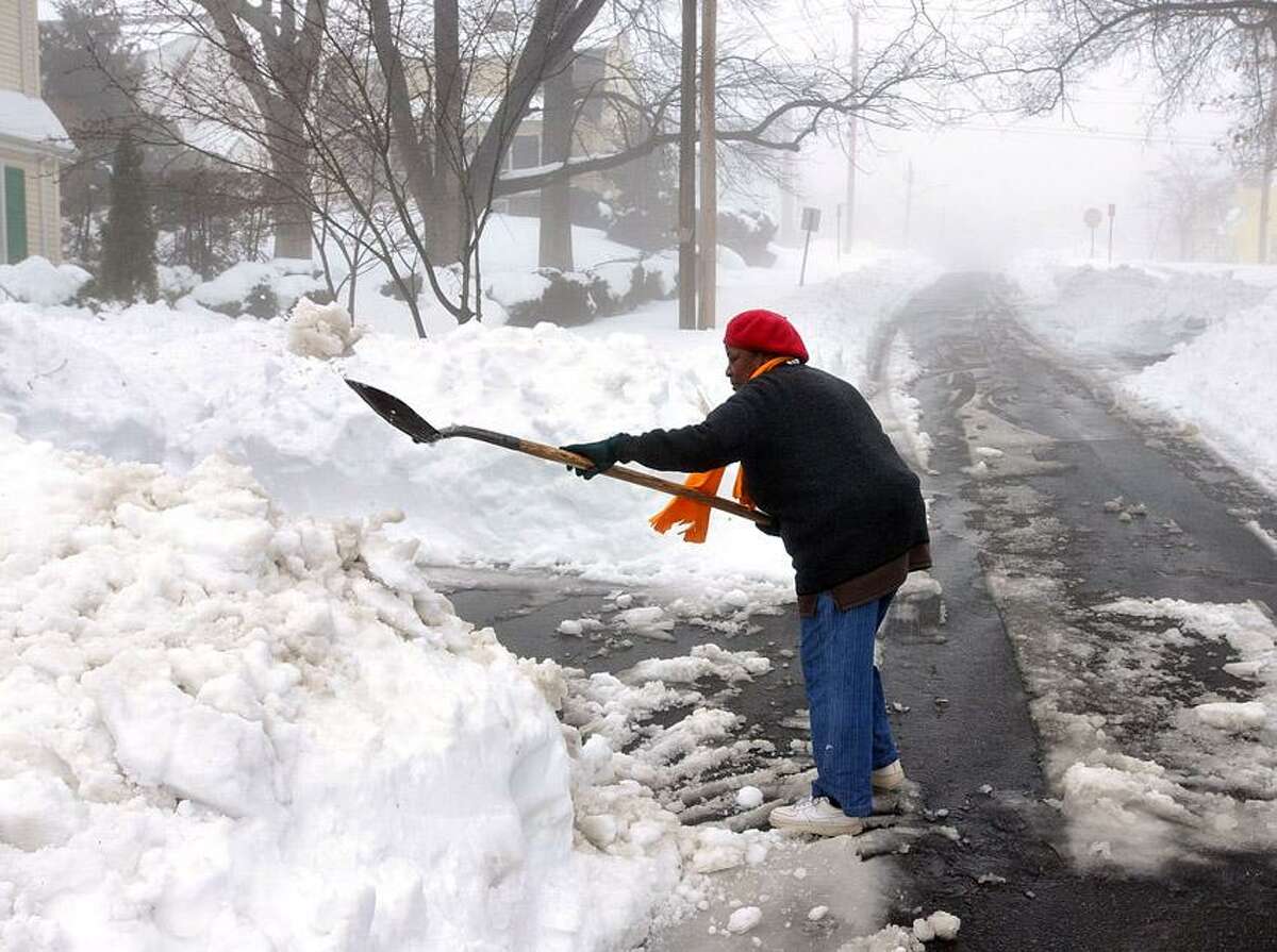 New Haven--Willie Mae Samuel shovels her driveway in Upper Westville as the rain fell causing foggy conditions . Photo-Peter Casolino 2/11/13