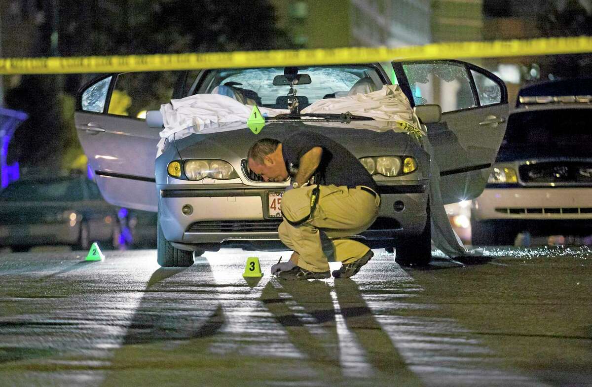 In this July 16, 2012 photo, Boston Police investigate a car in which Daniel de Abreu and Safiro Furtado were shot to death near the intersection of Herald Street and Shawmut Avenue in Boston. Prosecutors on Thursday, May 15, 2014 announced that former New England Patriots star Aaron Hernandez had been indicted on murder charges in their deaths. Hernandez is awaiting trial in a separate 2013 shooting death of Odin Lloyd, whose body was found in North Attleborough, Mass., not far from Hernandez's home. (AP photo/Courtney Sacco)