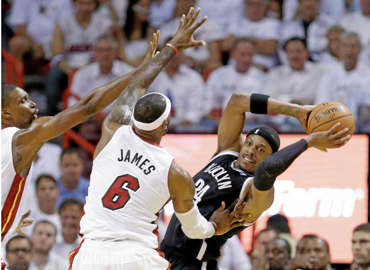 Brooklyn Nets forward Paul Pierce (34) looks for an open teammate as LeBron James and Chris Bosh, left, defend.