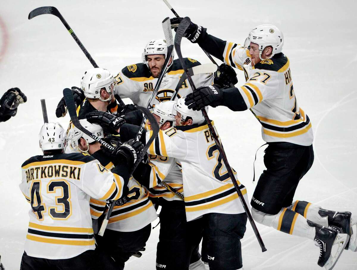 The Bruins’ Matt Fraser is mobbed by teammates after scoring the game-winning goal against the Montreal Canadiens during the first overtime period in Game 4 in the second round of the NHL Stanley Cup playoffs Thursday.