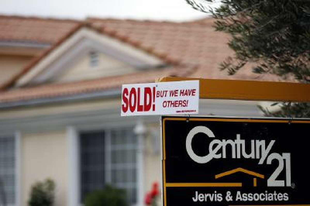 A real estate sign is seen outside a home in Downey, Calif., Wednesday, Jan. 23, 2013.