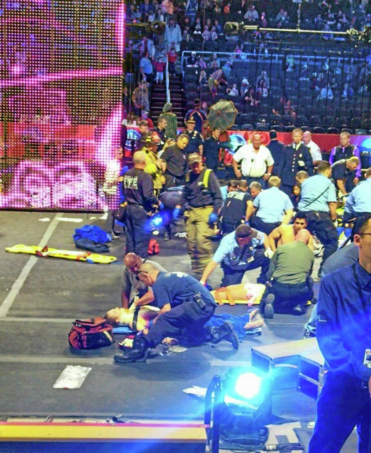 In this photo provided by Rosa Viveiros, first responders work at the center ring after a platform collapsed during an aerial hair-hanging stunt at the Ringling Brothers and Barnum and Bailey Circus, Sunday, May 4, 2014, in Providence, R.I. At least nine performers were seriously injured in the fall, including a dancer below, while an unknown number of others suffered minor injuries. (AP Photo/Rosa Viveiros) MANDATORY CREDIT