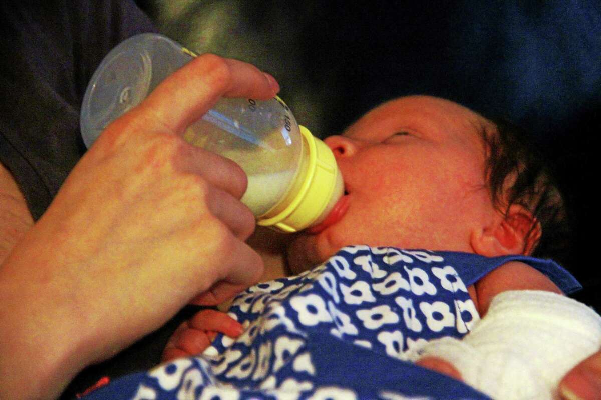 Zoe Fortier nurses from a bottle in her mother’s arms on Aug. 29, in Torrington. The 1-month old girl has a rare disorder that makes her bones fragile and prone to injury.