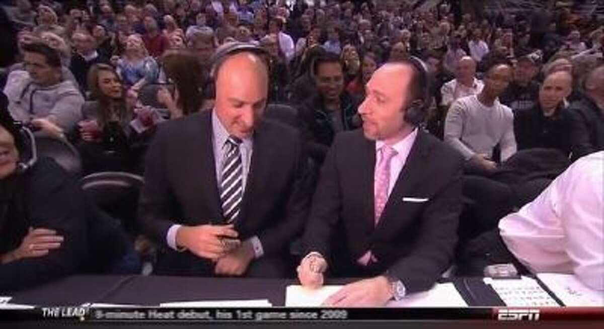ESPN broadcasters Jon Barry (left) and Dave Pasch flip a coin to see who has to interview Greg Popovich.