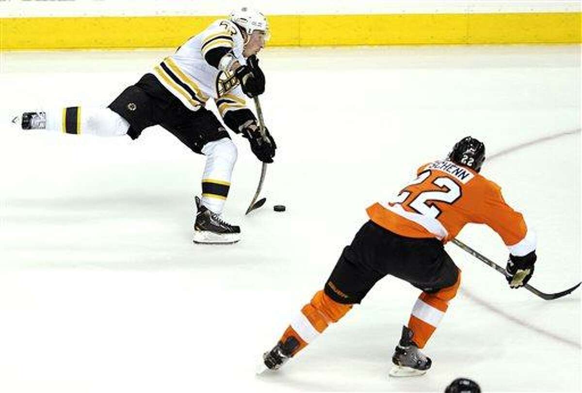 Boston Bruins' Brad Marchand (63) shoots on goal as Philadelphia Flyers' Luke Schenn (22) defends in the third period of an NHL hockey game, Saturday, March 30, 2013, in Philadelphia. The Flyers won 3-1. (AP Photo/Michael Perez)