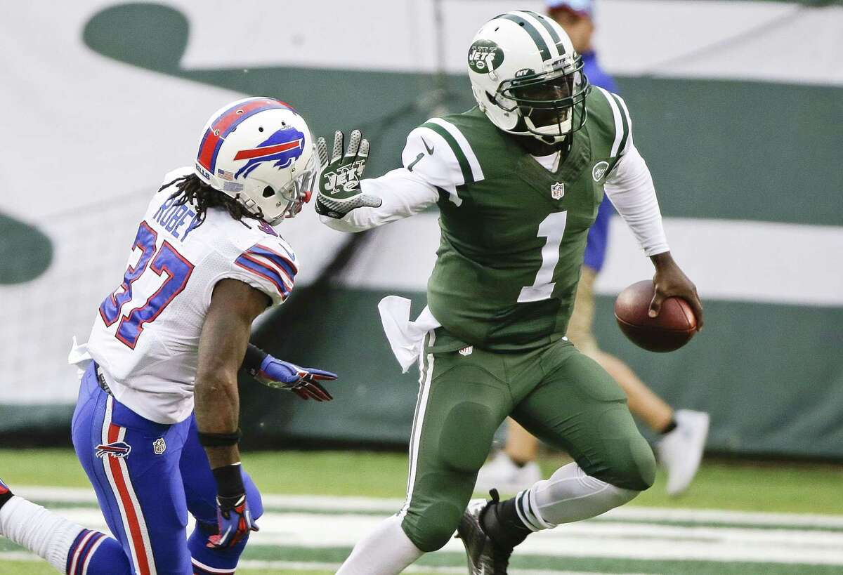 New York Jets quarterback Michael Vick (1) stiff arms the Buffalo Bills’ Nickell Robey (37) during the second half of Sunday’s game in East Rutherford N.J.