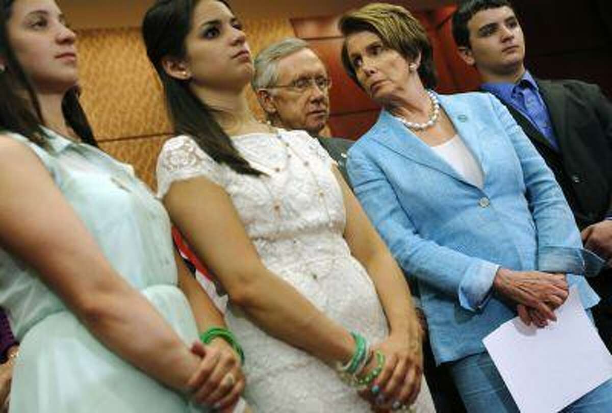 Senate Majority Leader Harry Reid, D., Nev., (center) and House Minority Leader Nancy Pelosi, D., Calif., (second from right) stand with Jillian Soto, Carlee Soto and Carlos Soto, siblings of slain Sandy Hook Elementary School teacher Victoria Soto, at a news conference about gun violence legislation on the six-month anniversary of the Connecticut shootings, at the U.S. Capitol in Washington, June 13, 2013.
