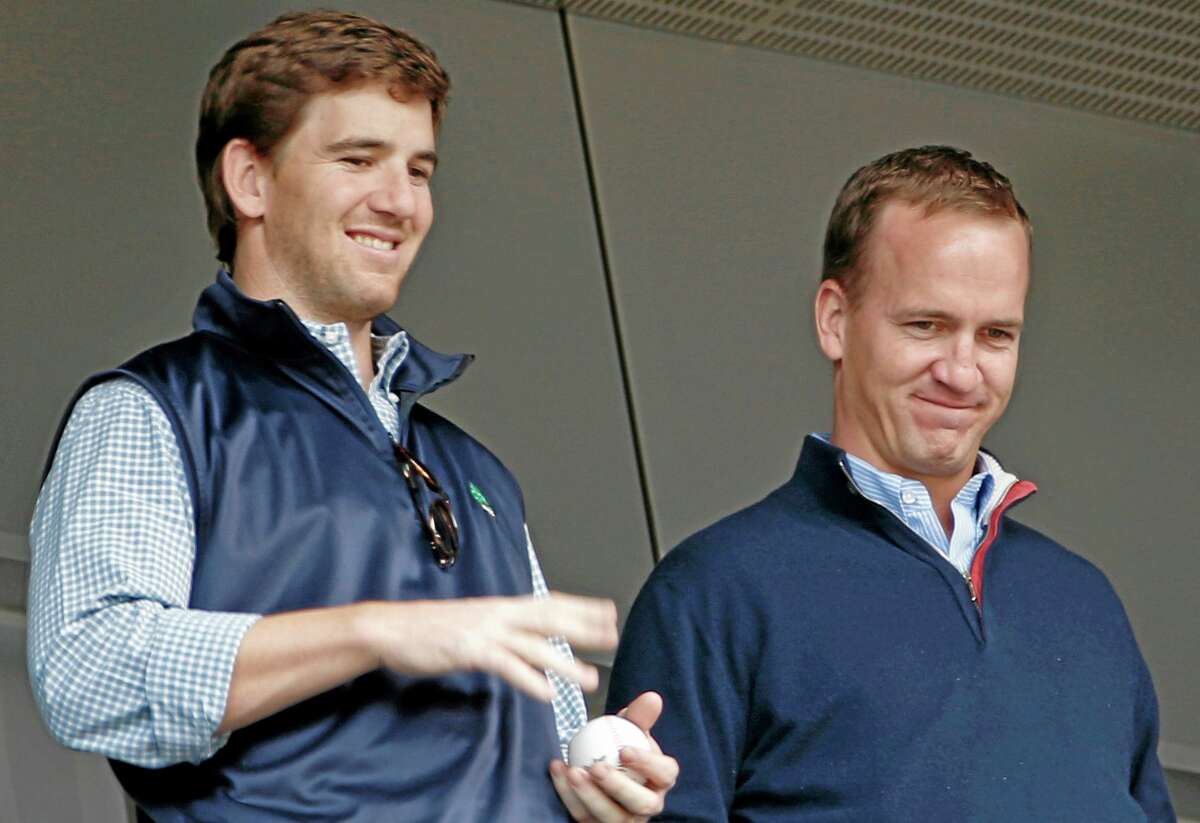 Broncos quarterback Peyton Manning, right, and his brother, Giants quarterback Eli Manning, watch from New York Yankees’ Derek Jeter’s suite during Sunday’s game between the Yankees and the Tampa Bay Rays at Yankee Stadium.
