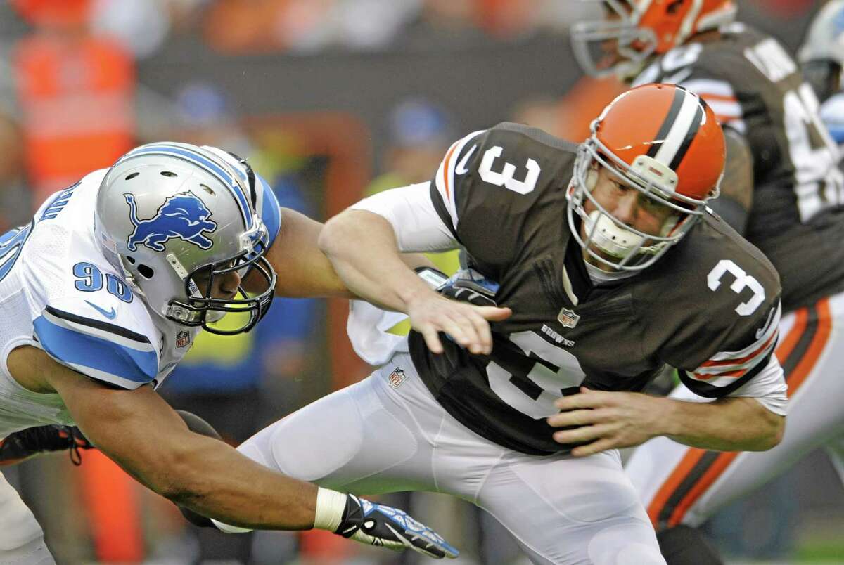 FILE - In this Oct. 13, 2013, file photo, Cleveland Browns quarterback Brandon Weeden (3) is hit by Detroit Lions defensive tackle Ndamukong Suh after throwing a pass in the first quarter of an NFL football game in Cleveland. The league is reviewing Suh's play against Cleveland. The hit, which wasn't penalized, was shown on a video posted on NFL.com on Tuesday, Oct. 15, 2013, as vice president of officiating Dean Blandino said, "Why don't we look at it some more?" in the league's officiating command center. (AP Photo/David Richard, File)