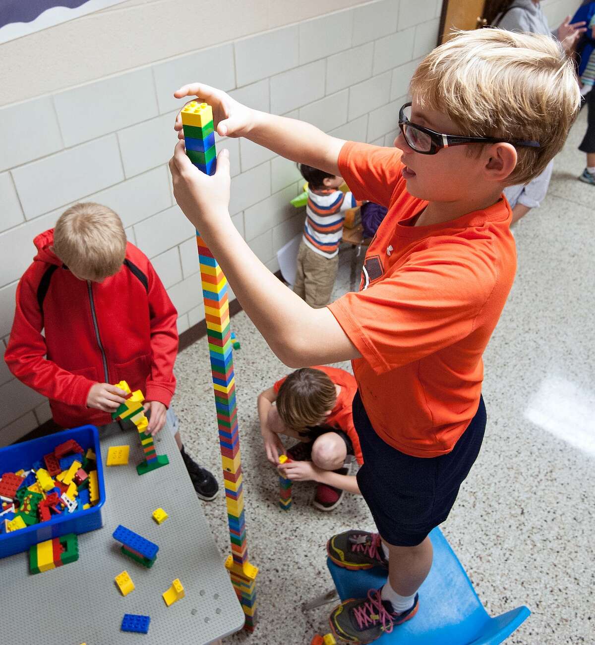 Jax Lassiter, 11, of Bridgewater, precariously adds another Lego to his tower just moments before its collapse during STEAM night (Science, Technology, Engineering, Arts, and Mathematics) at John Wayland Elementary School in Bridgewater, Va., on Thursday night, Oct. 16, 2014. (AP Photo/The Daily News-Record, Jason Lenhart)