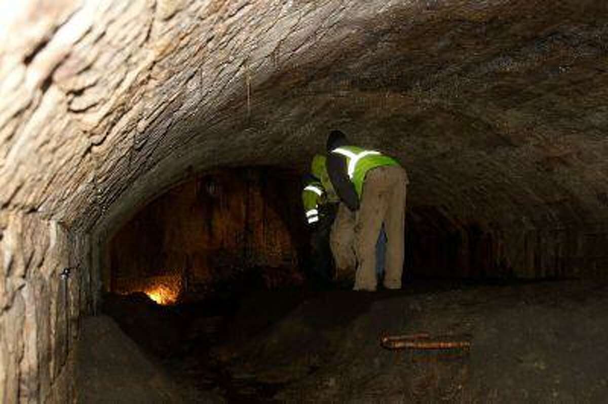 Amherst, Ohio, city workers inspect part of the long tunnel of the underground chamber found last week behind Amherst City Hall.
