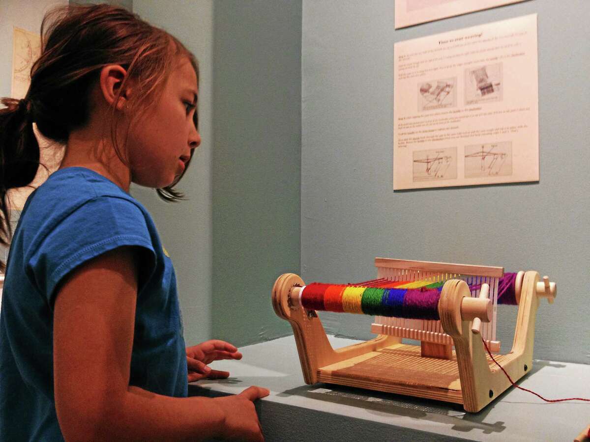 Clarissa Tranquillo, 6, looks at a weaving tool during the Litchfield History Museum Family Day on Saturday, May 3, 2014, in Litchfield. Esteban L. Hernandez Register Citizen