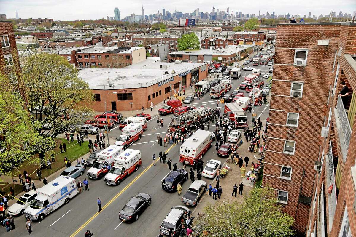 New York City emergency crews converge at 60th Street and Broadway to evacuate passengers from a subway train after it derailed in the Queens borough of New York, Friday, May 2, 2014. The express F train was bound for Manhattan and Brooklyn when it derailed at 10:40 a.m. about 1,200 feet (365 meters) south of the 65th Street station, according to the Metropolitan Transportation Authority. Dozens of firefighters and paramedics with stretchers converged on Broadway and 60th Street, where passengers calmly left the tunnel through the sidewalk opening. A few were treated on stretchers. (AP Photo/Julie Jacobson)