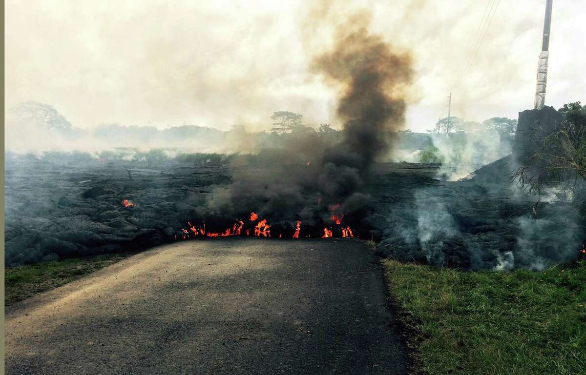 In this Oct. 24, 2014 photo from the U.S. Geological Survey, the lava flow from Kilauea Volcano that began June 27 is seen near the town of Pahoa on the Big Island of Hawaii. Authorities on Saturday told several dozen residents near the active lava flow to prepare for a possible evacuation in the next three to five days as molten rock oozed across the country road and edged closer to homes.