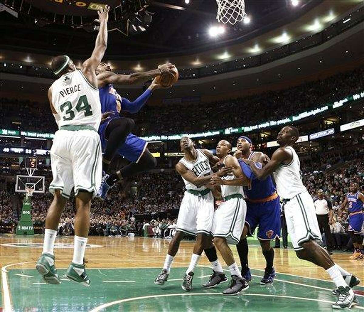 New York Knicks' J.R. Smith (8) drives to the basket past Boston Celtics' Paul Pierce (34) as Jordan Crawford, right, Avery Bradley, and Jeff Green, left, fight Knicks' Carmelo Anthony for position during the second quarter of a, NBA basketball game in Boston, Tuesday, March 26, 2013. (AP Photo/Winslow Townson)