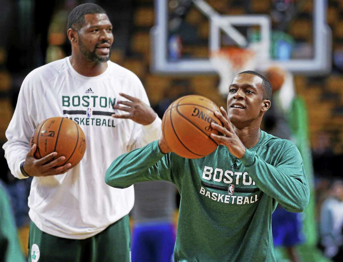 Celtics guard Rajon Rondo, right, shoots during pregame warm-ups as assistant coach Walter McCarty watches prior to a Dec. 11, 2013 game in Boston.
