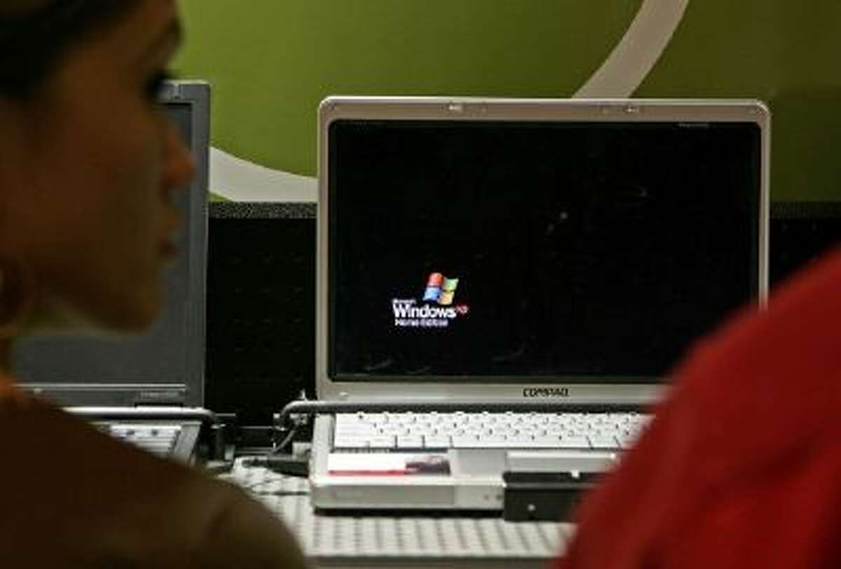 A customer looks at a laptop that is using Microsoft Windows XP operating system software at a CompUSA store March 22, 2006 in San Francisco, California.