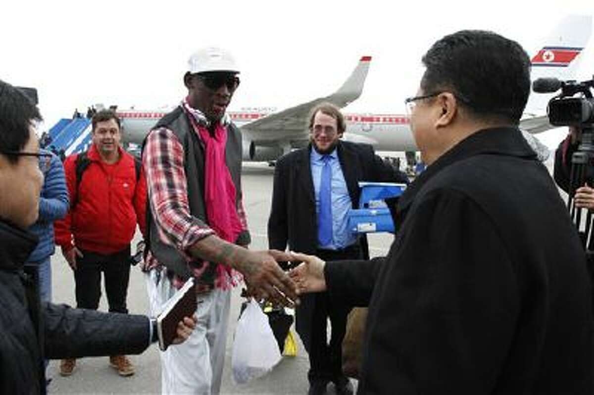 Former NBA basketball star Dennis Rodman shakes hands with North Korea's Sports Ministry Vice Minister Son Kwang Ho upon his arrival at the international airport in Pyongyang, North Korea.