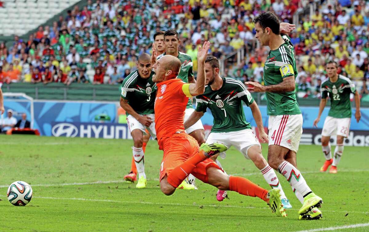 The Netherlands’ Arjen Robben, center, goes down to earn a penalty during Sunday’s match against Mexico.