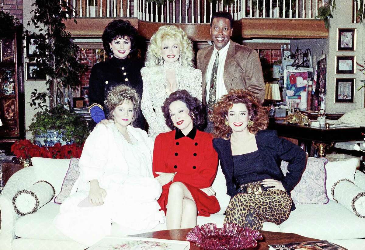Singer and actress Dolly Parton, top center, joins the cast of ìDesigning Womenî for the New Yearís Day episode of the show airing on CBS, taping at the Burbank Studios on Dec. 8, 1989 in Burbank, Calif. Flanking Parton from left are show costars Delta Burke and Meshach Taylor with seated left to right, Jean Smart, Dixie Carter and Annie Potts.