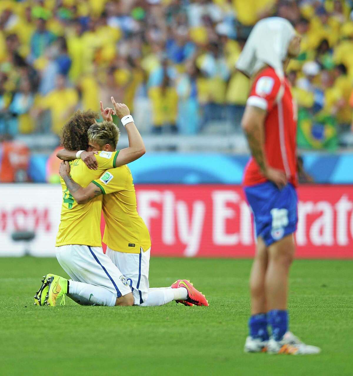Brazil’s David Luiz, left, and Neymar hug after a penalty shootout following regulation time during the World Cup Round of 16 match against Chile Saturday at the Mineirao Stadium in Belo Horizonte, Brazil.