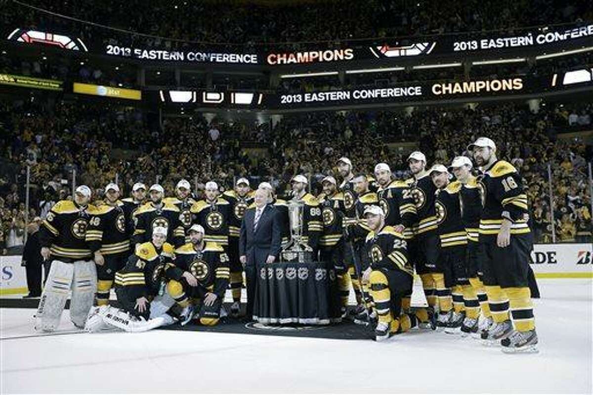 The Boston Bruins pose with the trophy after beating the Pittsburgh Penguins 1-0 in Game 4 of the Eastern Conference finals of the NHL hockey Stanley Cup playoffs, in Boston on Friday, June 7, 2013. The Bruins advanced to the Stanley Cup finals. (AP Photo/Elise Amendola)